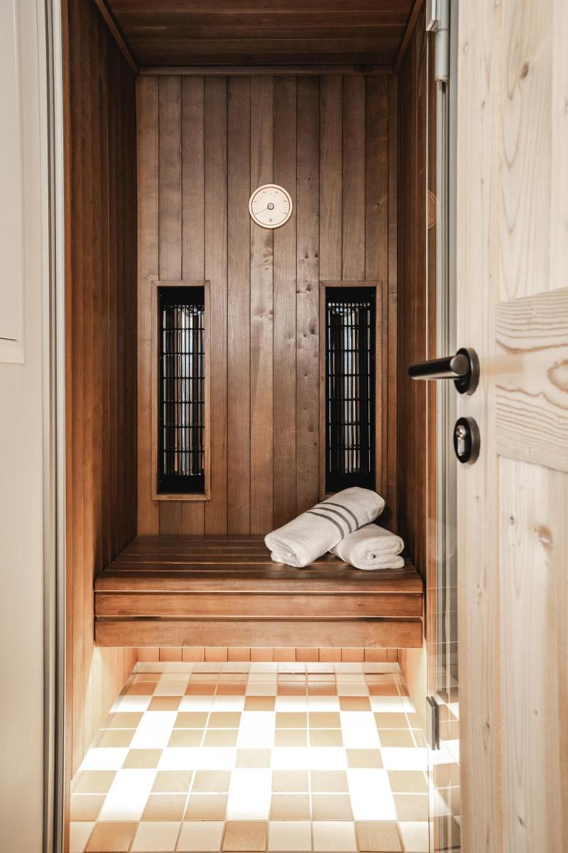 une pièce avec un banc, deux fenêtres et une horloge dans l'établissement Appartements de l'Héliopic, à Chamonix-Mont-Blanc