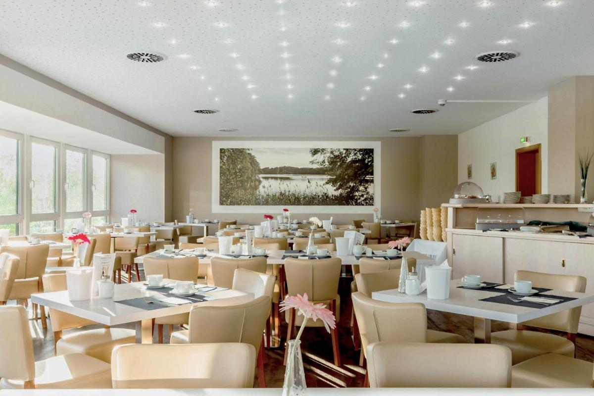 ein Esszimmer mit weißen Tischen und Stühlen in der Unterkunft Kaiserhof Feldberg by Belvilla Resorts in Feldberg