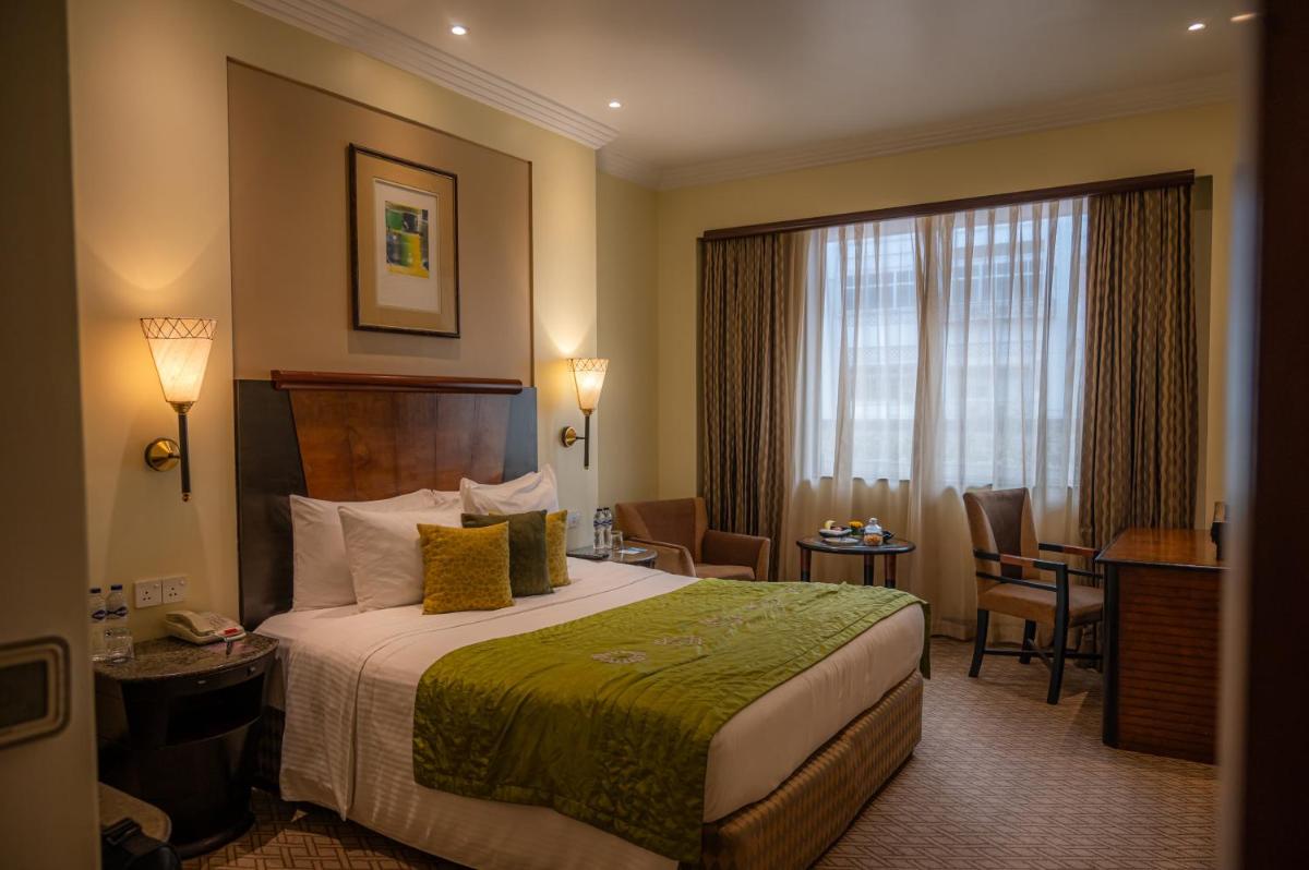 a hotel room with a bed and a table and chairs at The Park Kolkata in Kolkata