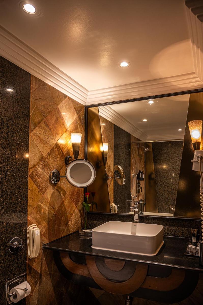 a bathroom with a sink and a large mirror at The Park Kolkata in Kolkata