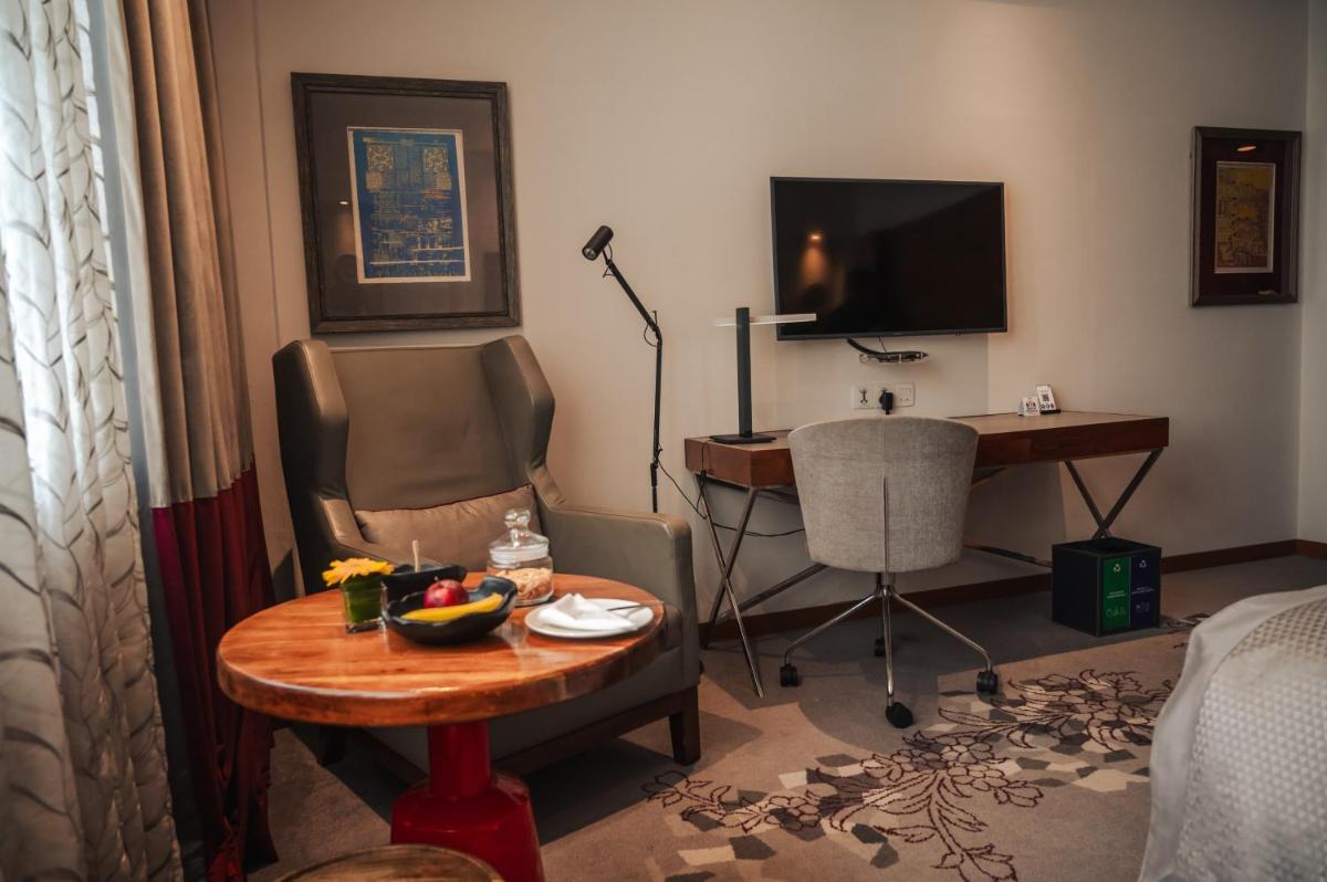 a room with a desk and a table with a bowl of fruit at The Park Kolkata in Kolkata