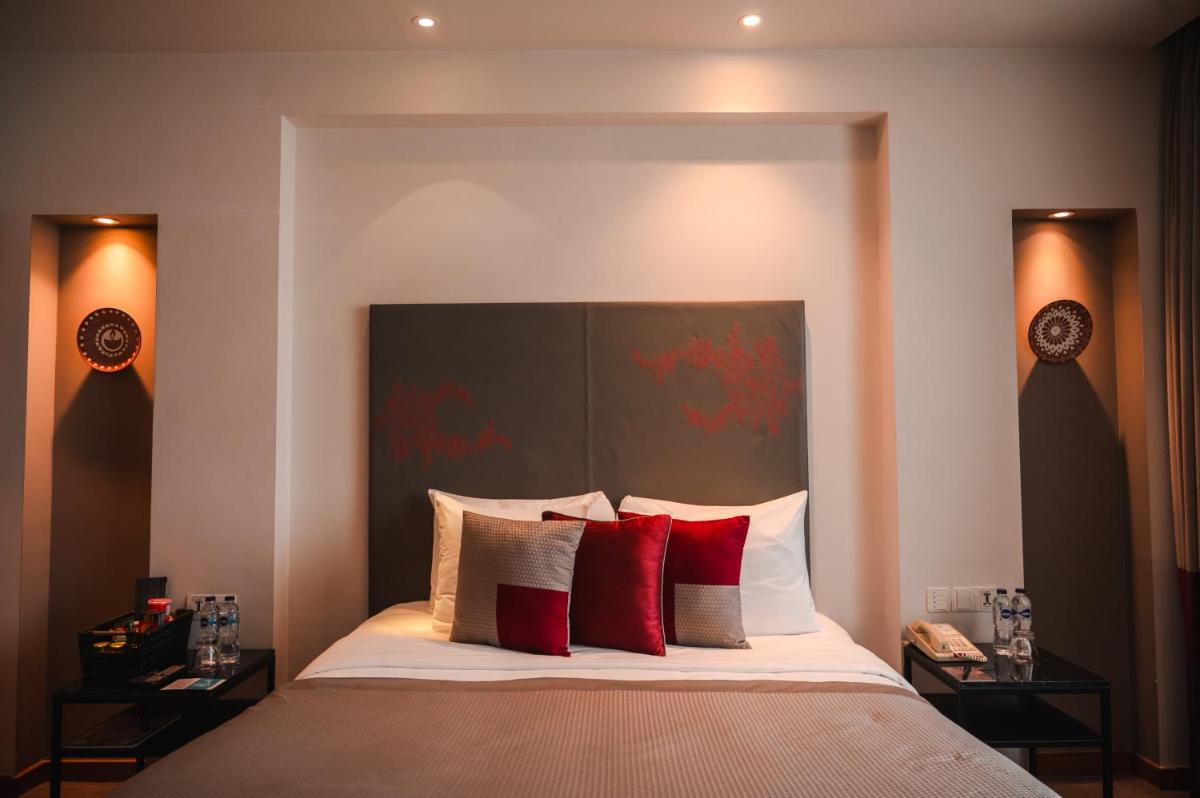 a bedroom with a large bed with red pillows at The Park Kolkata in Kolkata