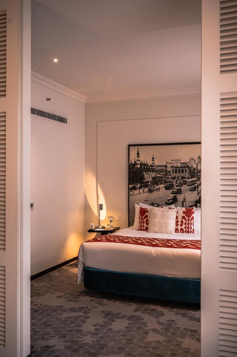 a bedroom with a bed with a painting on the wall at The Park Kolkata in Kolkata