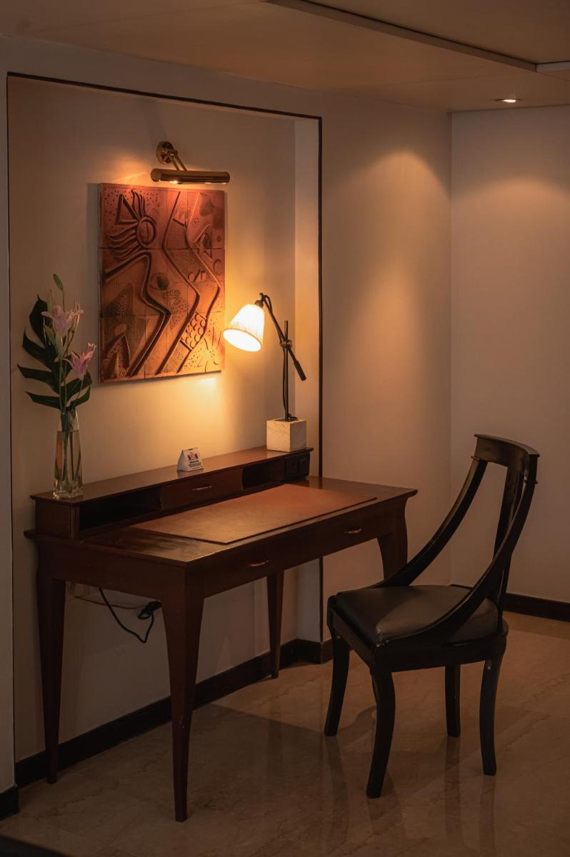 a desk with a lamp and a chair in a room at The Park Kolkata in Kolkata