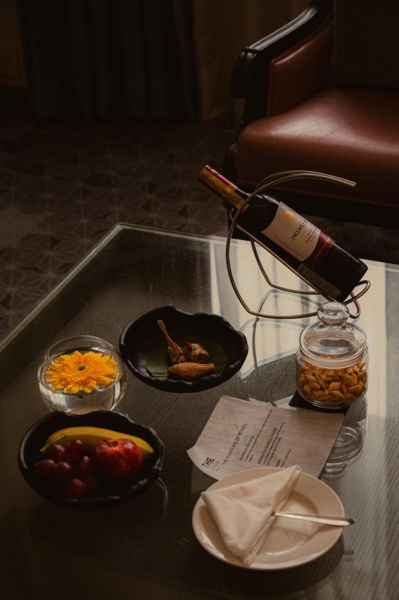 a glass table with a bottle of wine and food at The Park Kolkata in Kolkata