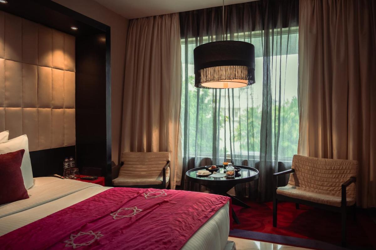 a bedroom with a bed and a table and a window at The Park Kolkata in Kolkata