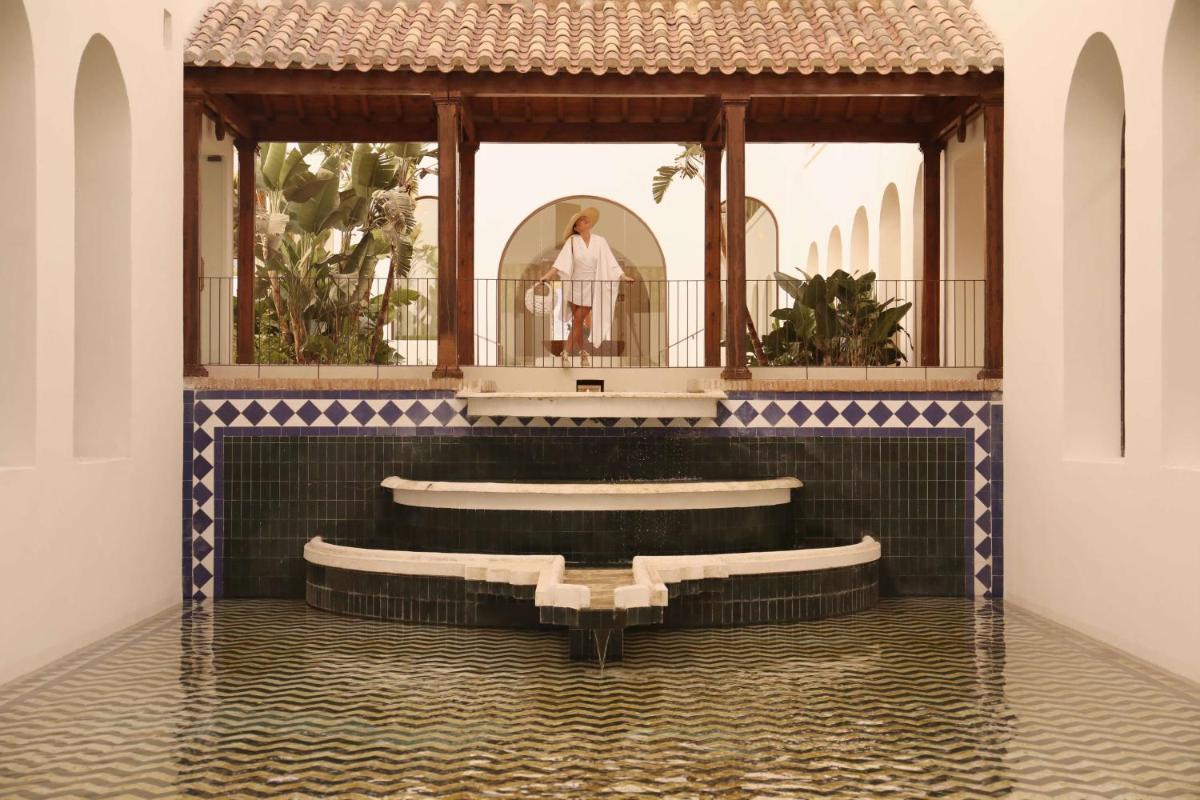 una iglesia con una mujer parada en un espejo en La Zambra Resort Mijas - Marbella - The Unbound Collection by Hyatt, en Mijas 160 fotos más