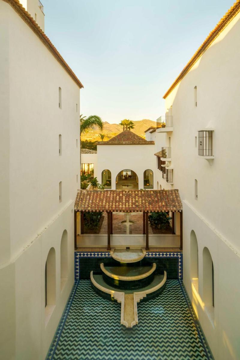 Un patio con una fuente en el medio de un edificio. en La Zambra Resort Mijas - Marbella - The Unbound Collection by Hyatt, en Mijas