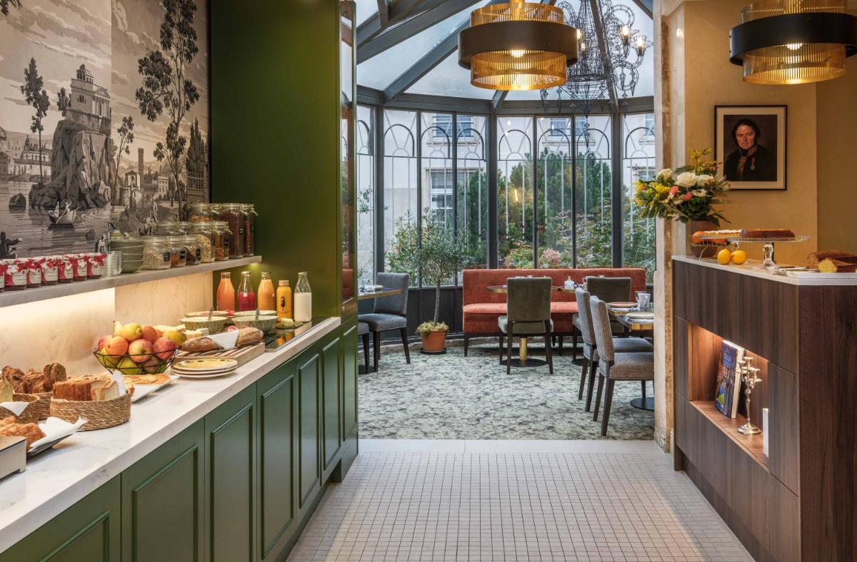 une salle à manger avec une table sur laquelle se trouve de la nourriture dans l'établissement Hôtel Littéraire Stendhal et Spa, à Nancy
