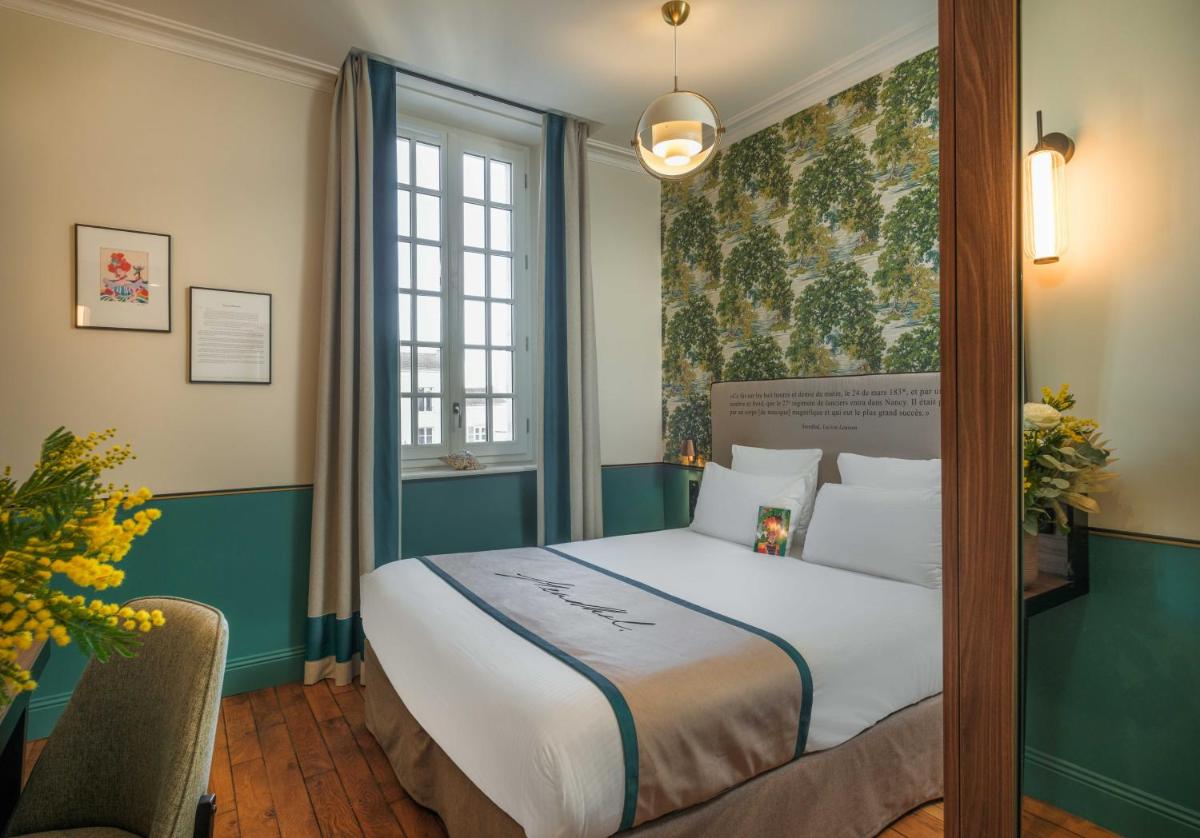une chambre avec un lit et un tableau au mur dans l'établissement Hôtel Littéraire Stendhal et Spa, à Nancy