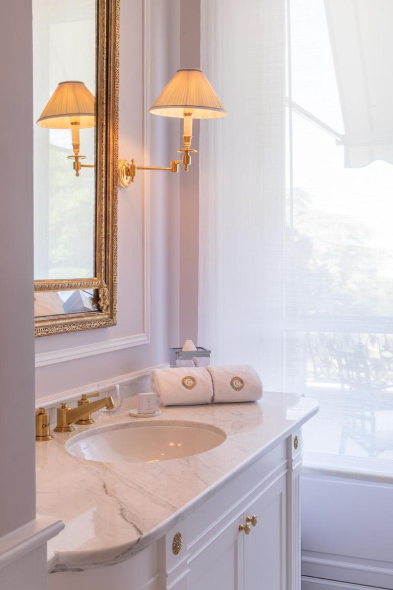 une salle de bain avec un lavabo et un miroir dans l'établissement Domaine les Crayères, à Reims