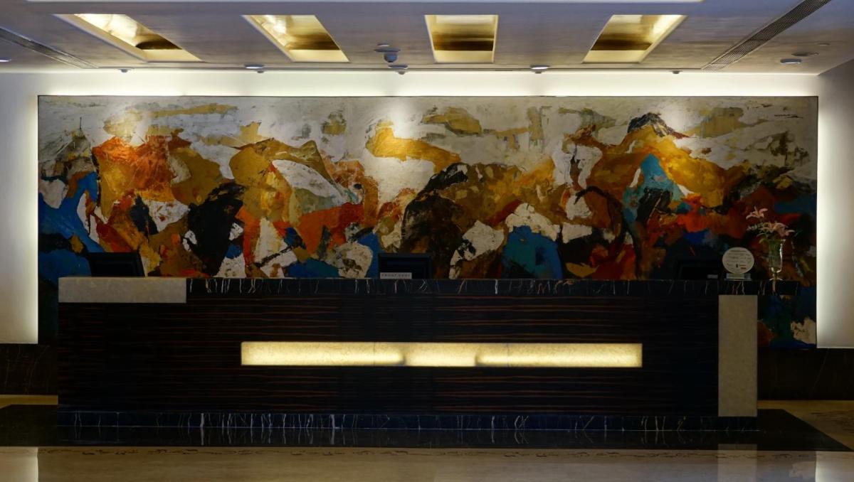 a wall with a large painting on the wall at Taj Chandigarh in Chandīgarh