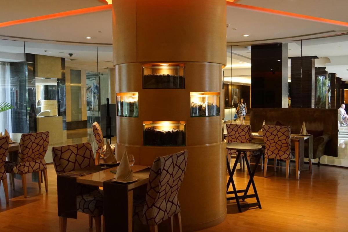 a restaurant with a table and chairs and a column at Taj Chandigarh in Chandīgarh