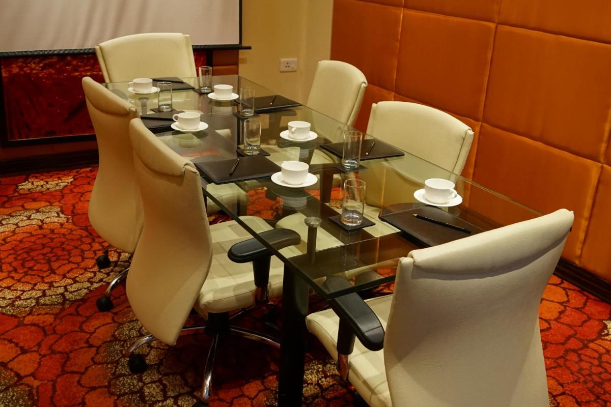 a dining room table with white chairs around it at Taj Chandigarh in Chandīgarh