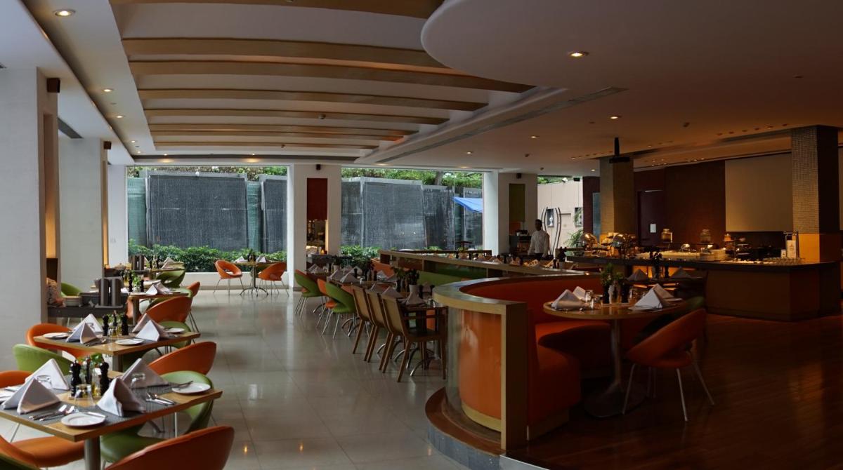 a restaurant with tables and chairs and a bar at Taj Chandigarh in Chandīgarh