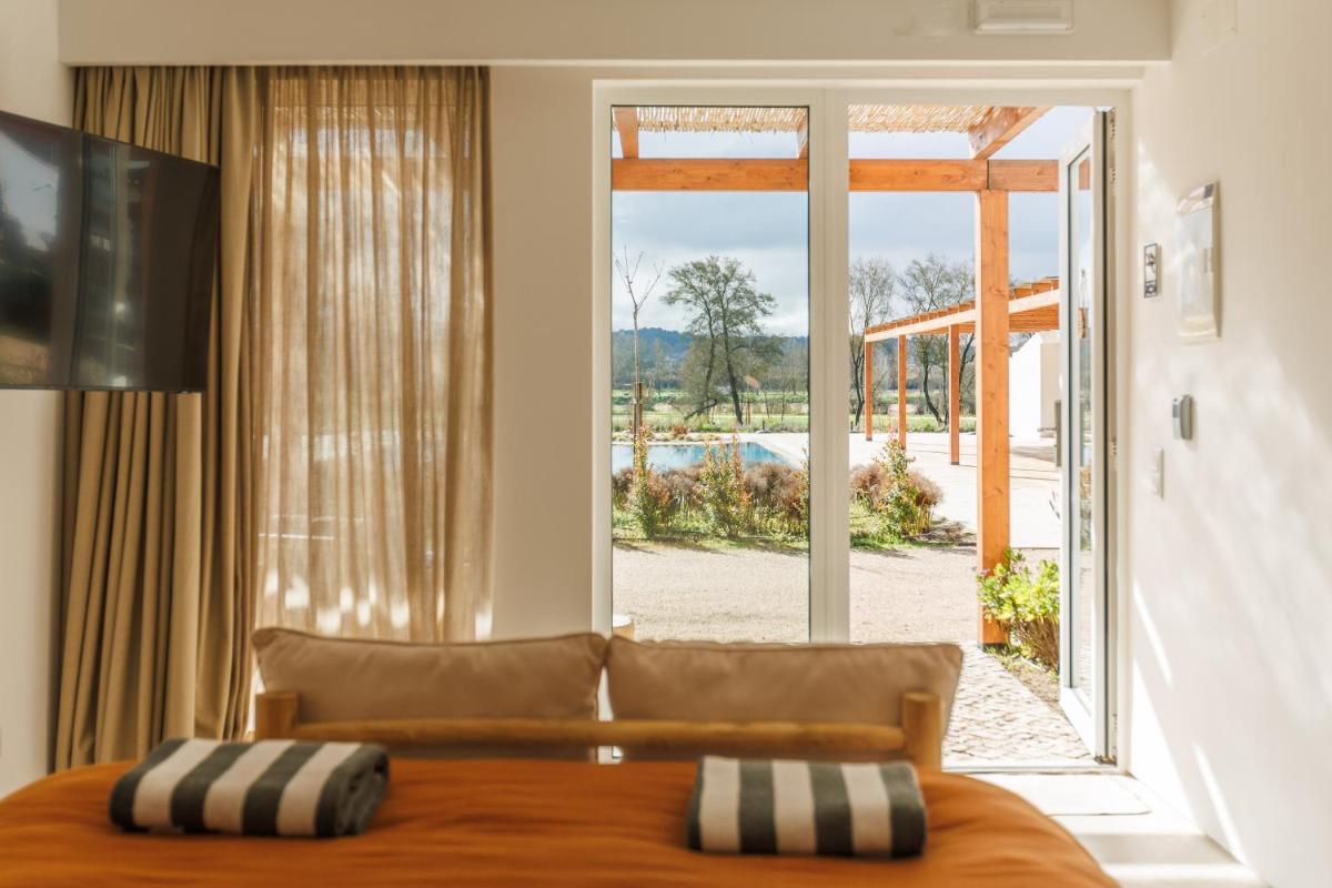 um quarto com uma cama e uma janela grande em Sorraia Hotel Rural em Santa Justa