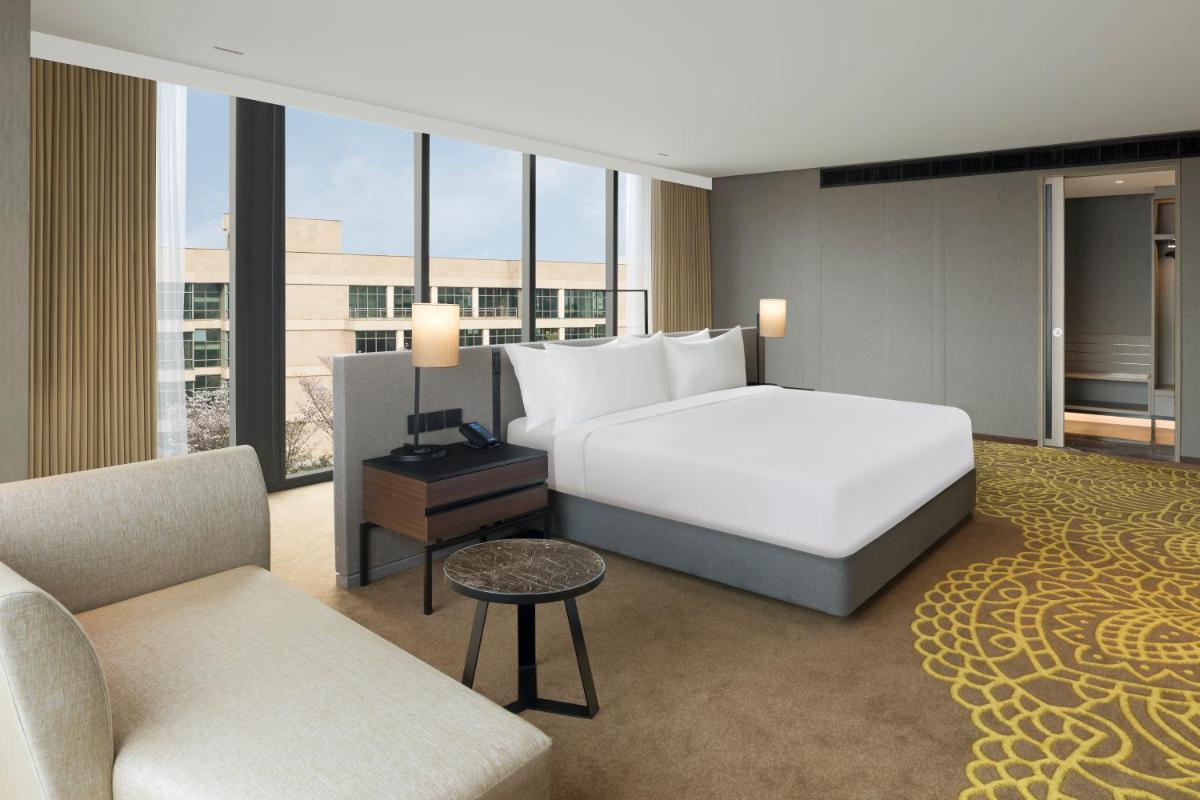 a hotel room with a bed and a couch at Hilton Bengaluru Embassy Manyata Business Park in Bengaluru