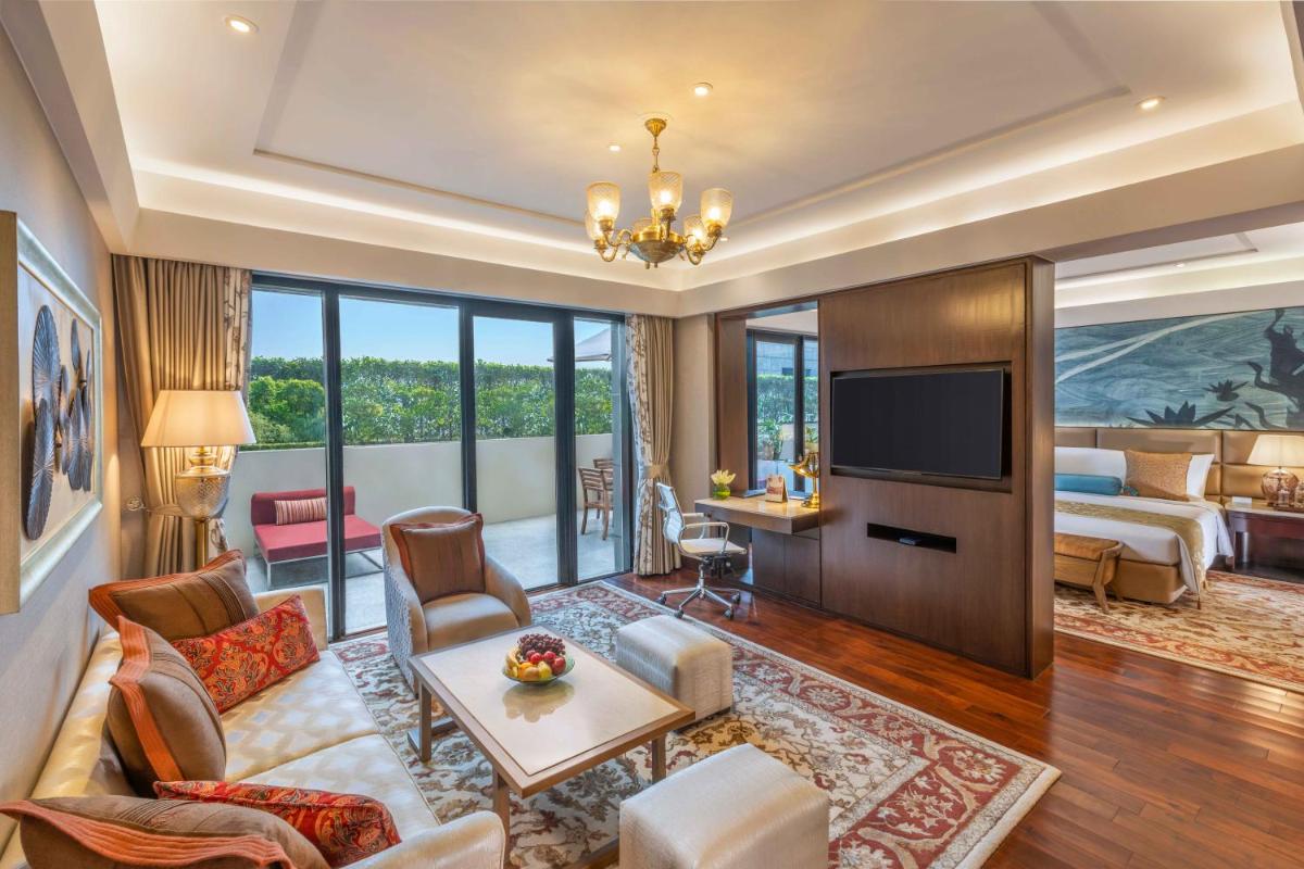 a living room with a couch and a tv at The Leela Ambience Convention Hotel Delhi in New Delhi