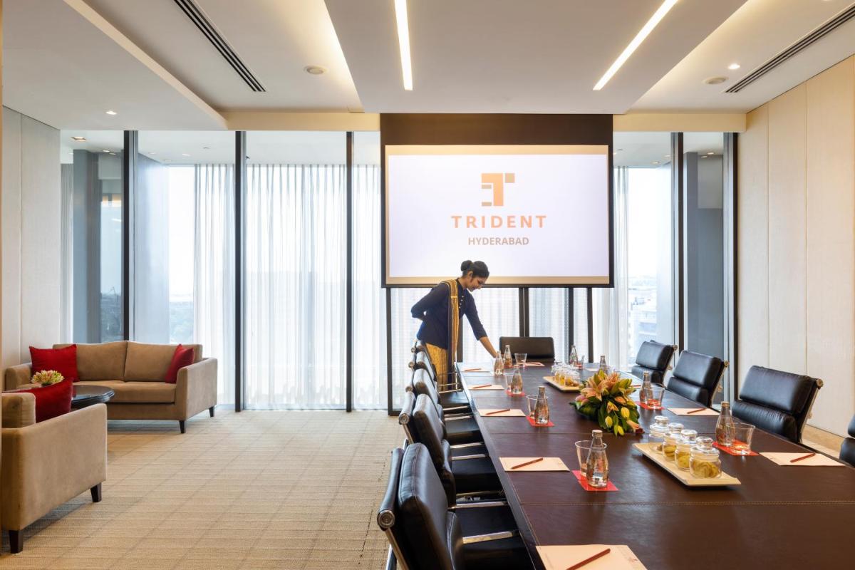 a man standing at a long table in a conference room at Trident Hyderabad in Hyderabad