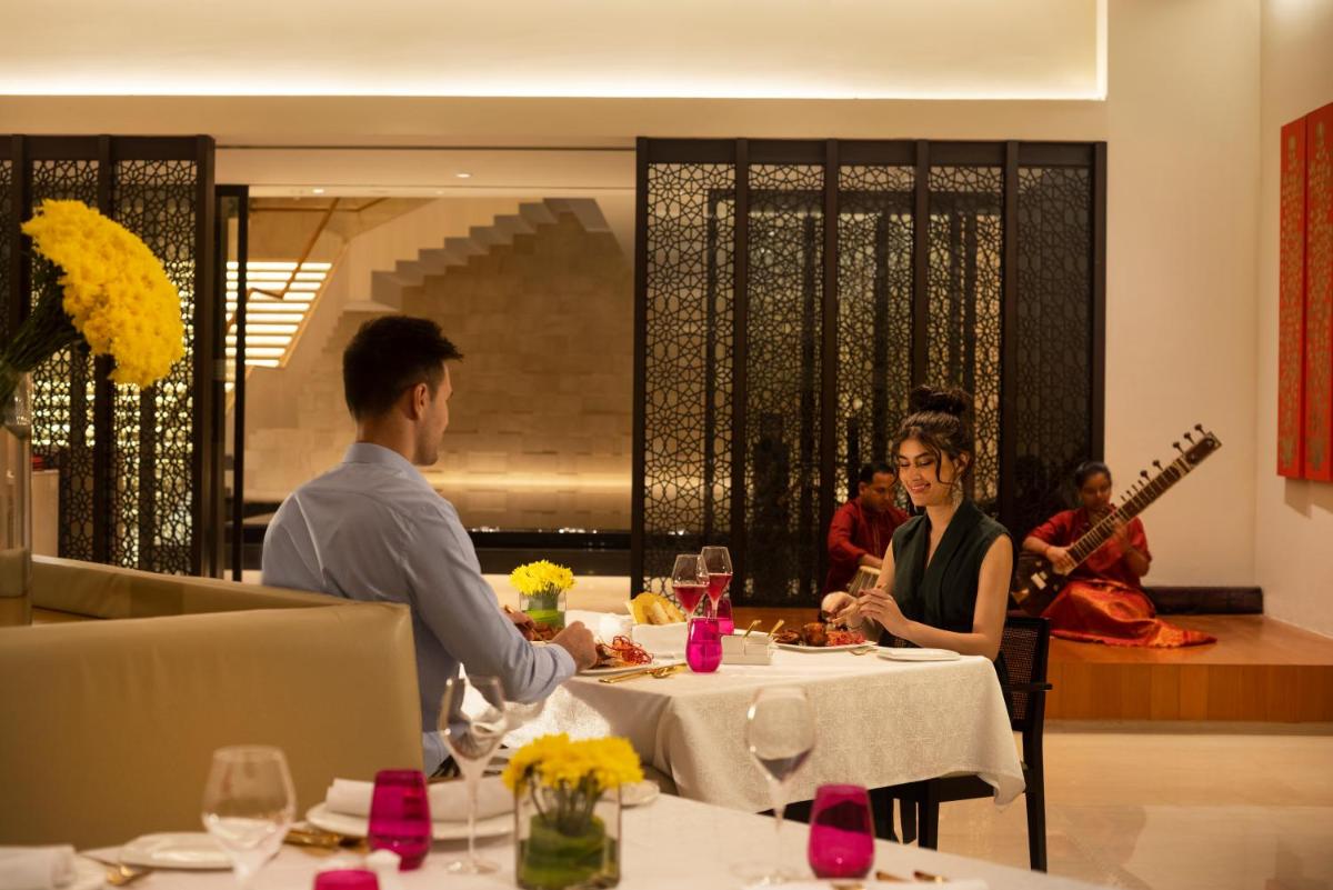 a man and woman sitting at a table in a restaurant at Trident Hyderabad in Hyderabad