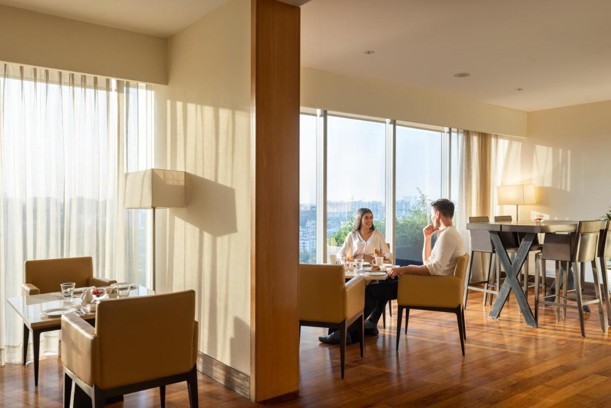 two people sitting at a table in a hotel room at Trident Hyderabad in Hyderabad