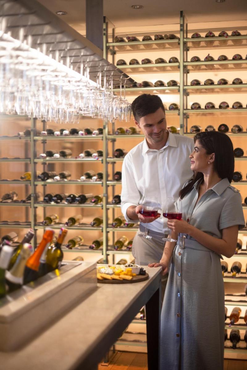 a man and a woman standing in a wine cellar at Trident Hyderabad in Hyderabad