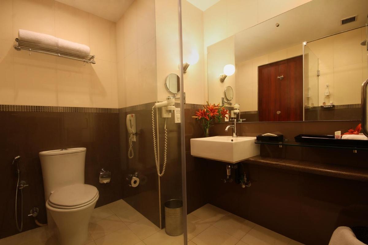 a bathroom with a toilet and a sink and a mirror at Fortune Select JP Cosmos, Bengaluru - Member ITC Hotels' Group in Bengaluru