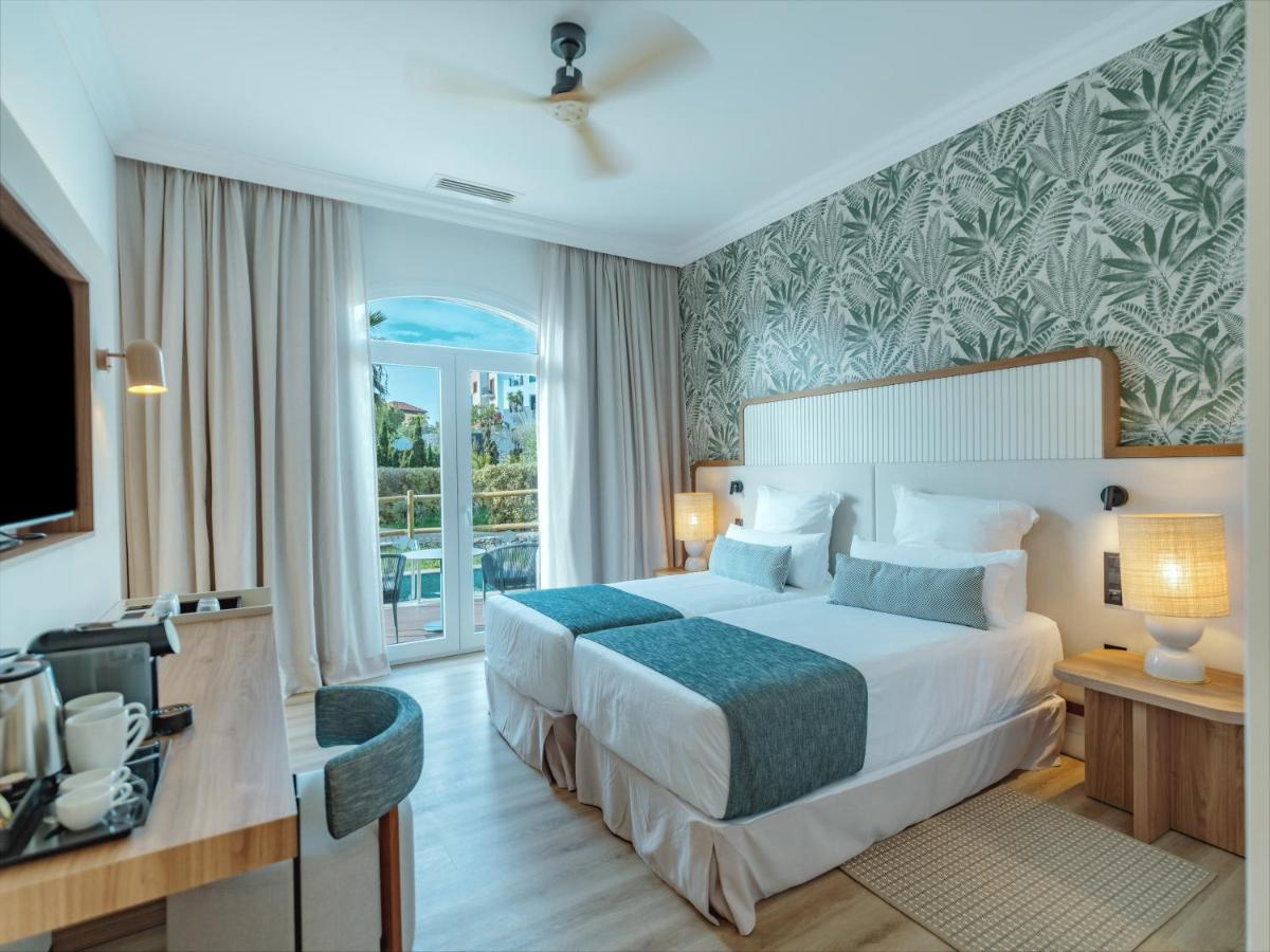Uma cama ou camas num quarto em Dreams Madeira Resort Spa & Marina