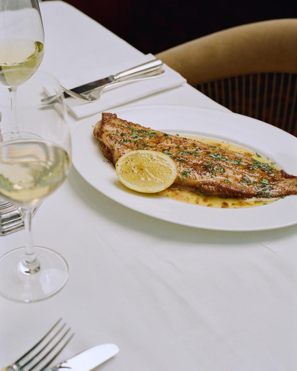 une assiette de poisson sur une table avec un verre de vin dans l'établissement Experimental Marais, à Paris 28 autres photos