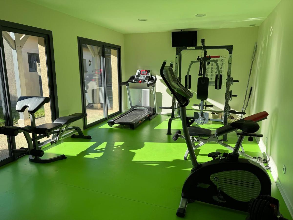 - une salle de sport avec plusieurs équipements d'exercice dans une salle verte dans l'établissement Logis La Venise Verte, à Soulaines-Dhuys