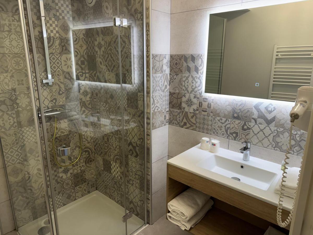 une salle de bain avec un lavabo et une douche dans l'établissement Logis La Venise Verte, à Soulaines-Dhuys