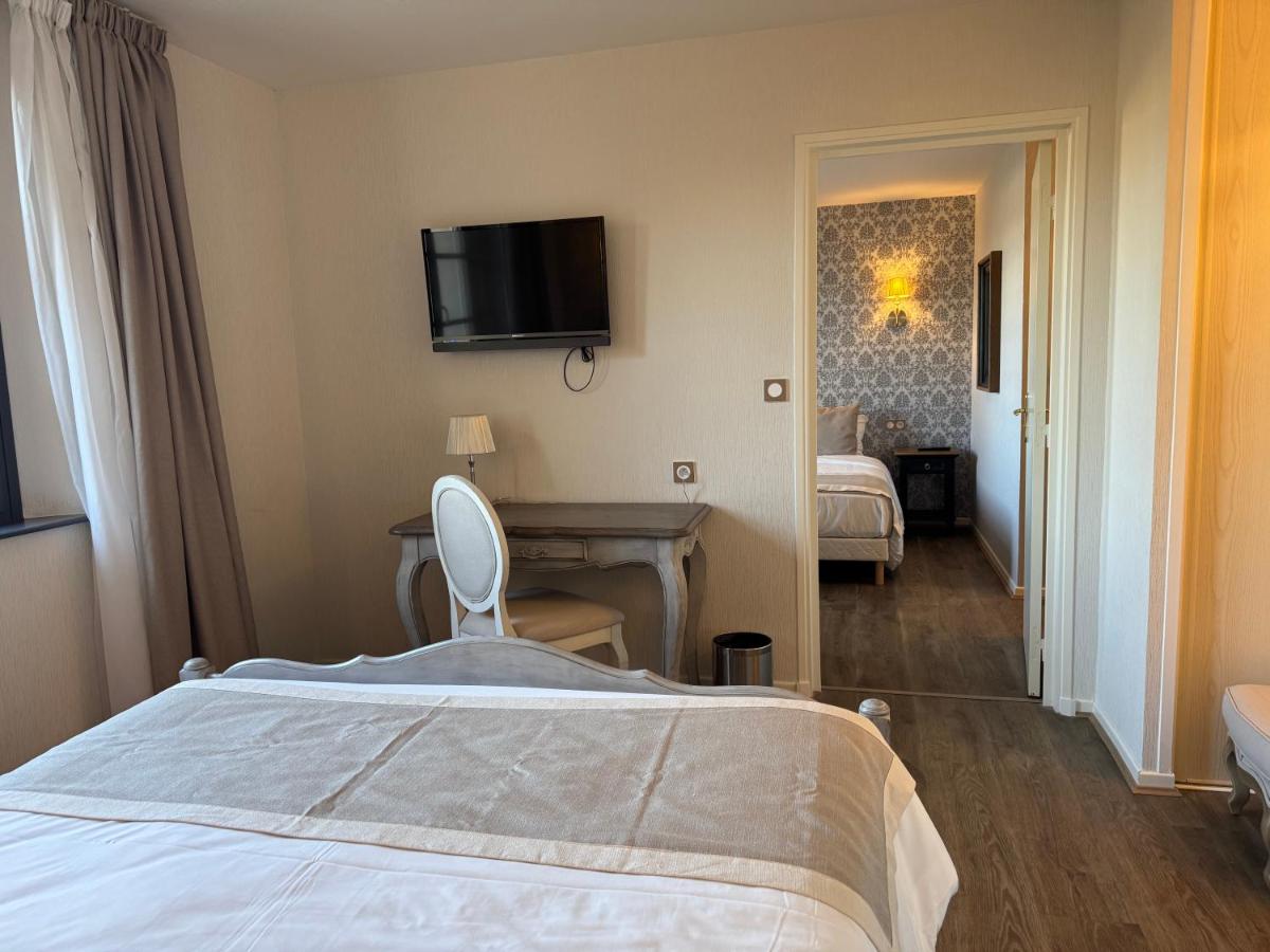 une chambre avec un lit, un bureau et une télévision dans l'établissement Logis La Venise Verte, à Soulaines-Dhuys