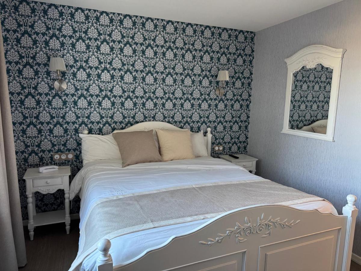- une chambre dotée d'un lit avec du papier peint bleu et blanc dans l'établissement Logis La Venise Verte, à Soulaines-Dhuys 11 autres photos