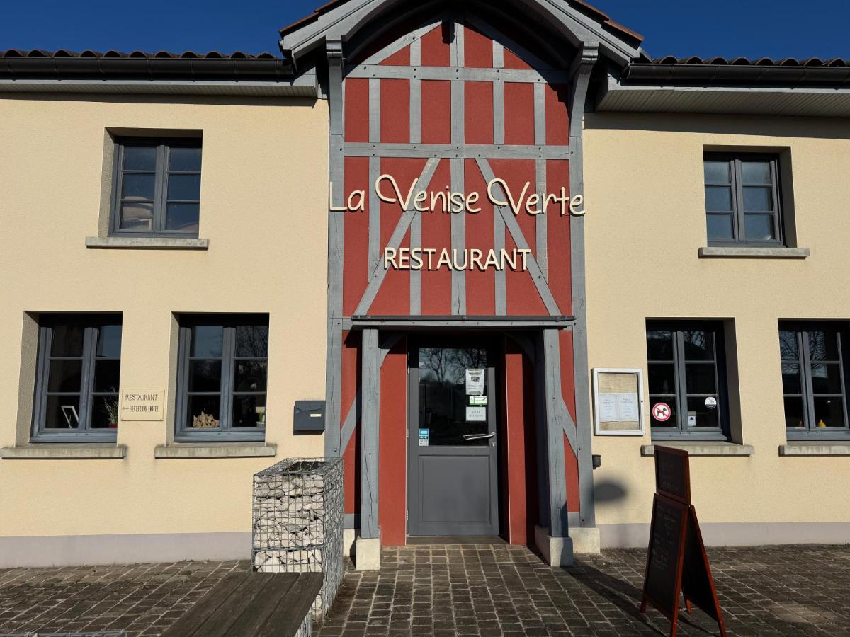 - un bâtiment avec une porte rouge et blanche dans l'établissement Logis La Venise Verte, à Soulaines-Dhuys