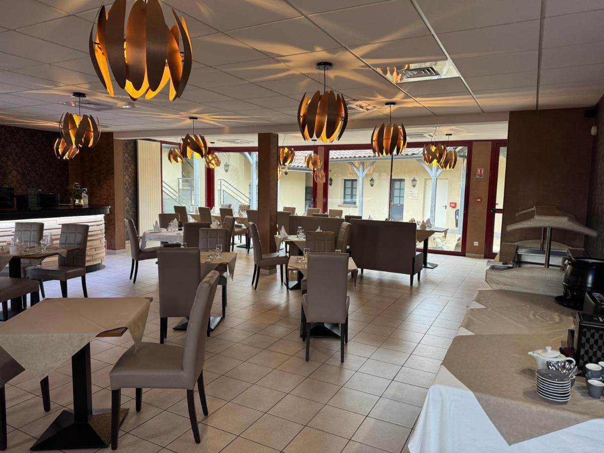une salle à manger avec tables, chaises et lustres dans l'établissement Logis La Venise Verte, à Soulaines-Dhuys