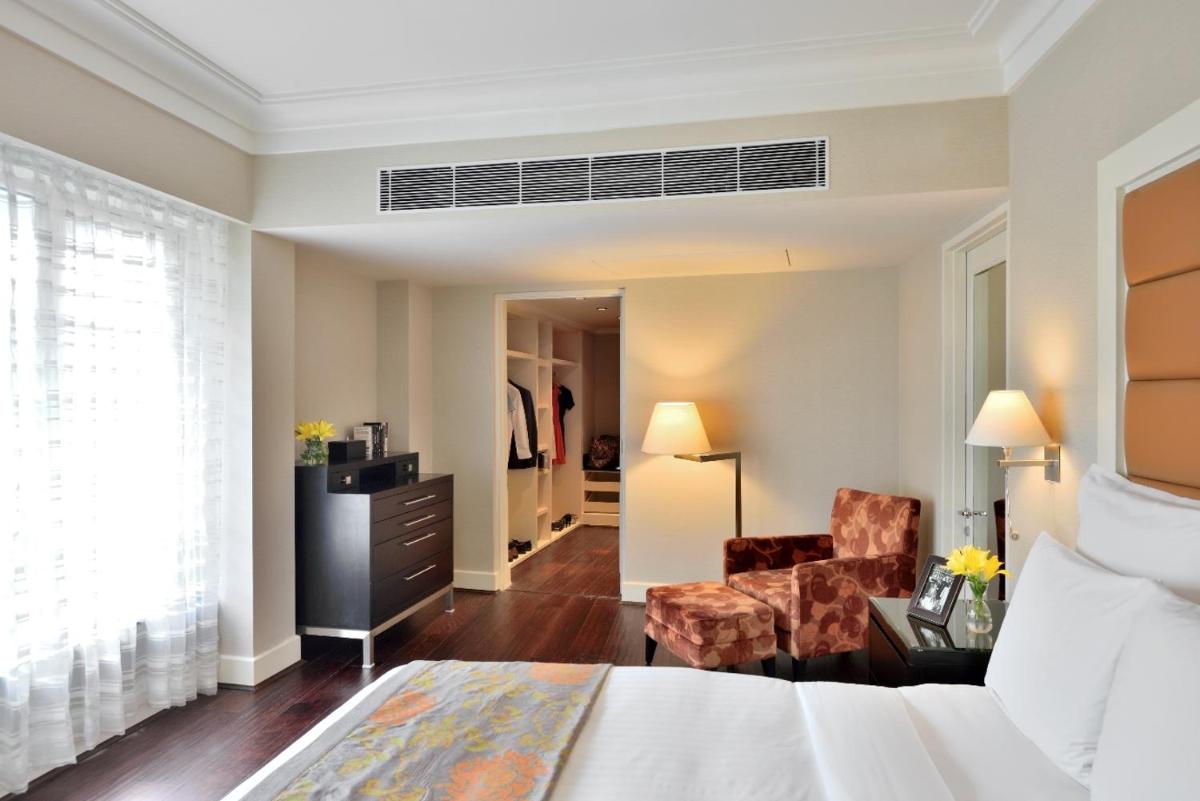 a hotel room with a bed and a chair at Marriott Executive Apartment - Lakeside Chalet, Mumbai in Mumbai +29 photos