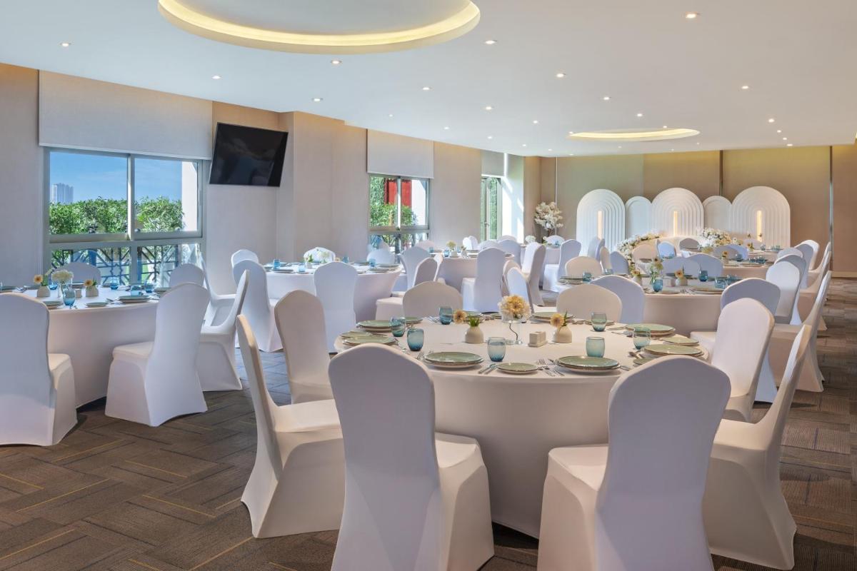 a room with white tables and white chairs at Barcelo Al Jaddaf, Dubai in Dubai +80 photos