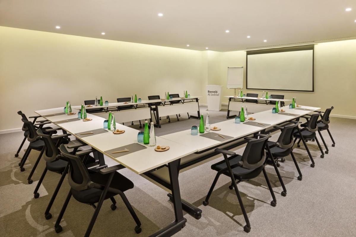a conference room with tables and chairs and a screen at Barcelo Al Jaddaf, Dubai in Dubai a conference room with tables and chairs and a screen at Barcelo Al Jaddaf, Dubai in Dubai