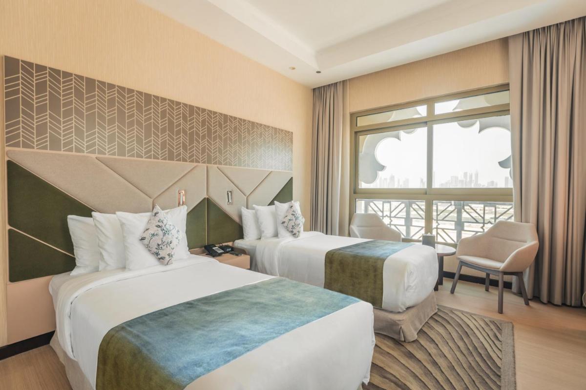 a hotel room with two beds and a window at Barcelo Al Jaddaf, Dubai in Dubai