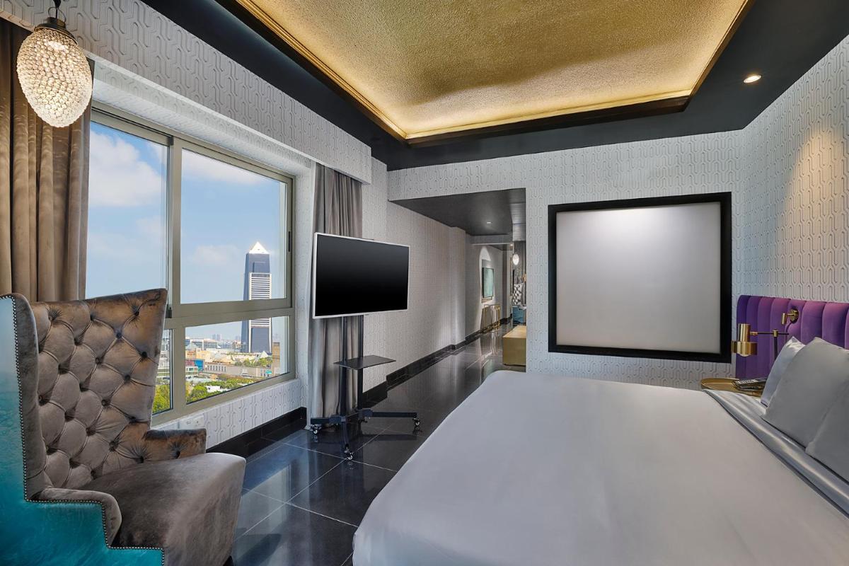 a hotel room with a bed and a flat screen tv at Barcelo Al Jaddaf, Dubai in Dubai