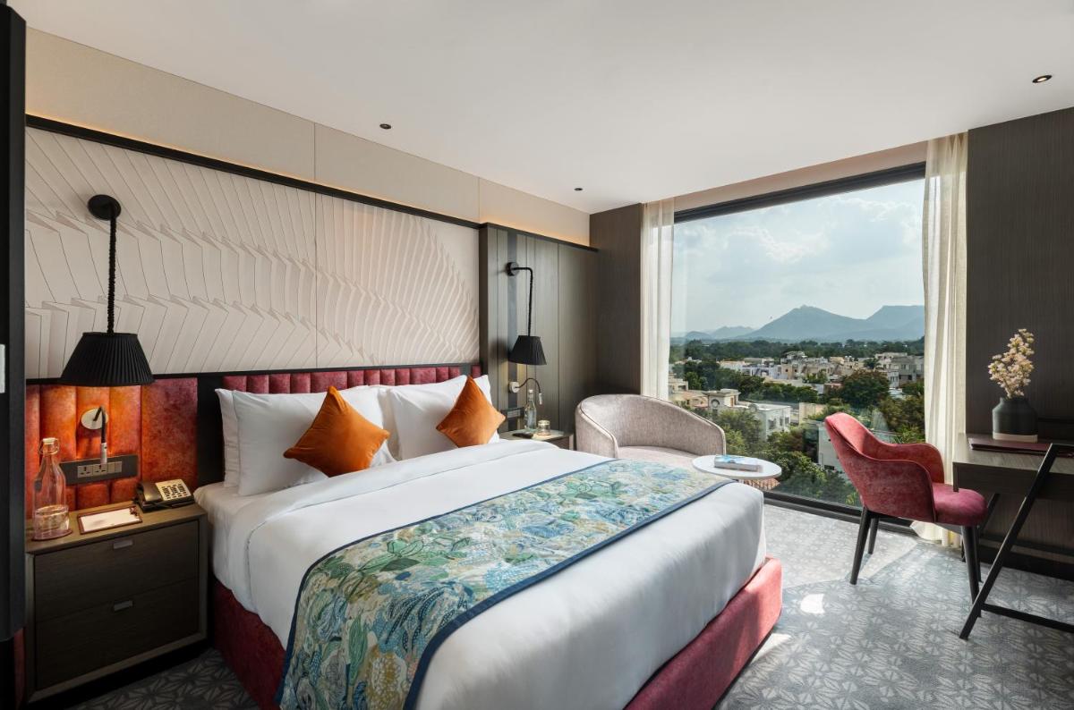 a hotel room with a bed and a large window at Parallel Hotel Udaipur, a member of Radisson Individuals in Udaipur