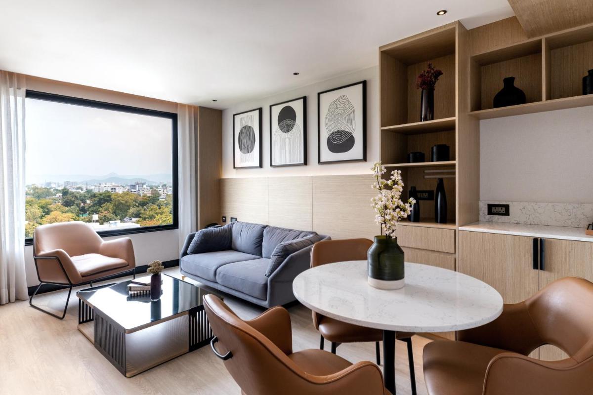 a living room with a couch and a table and chairs at Parallel Hotel Udaipur, a member of Radisson Individuals in Udaipur