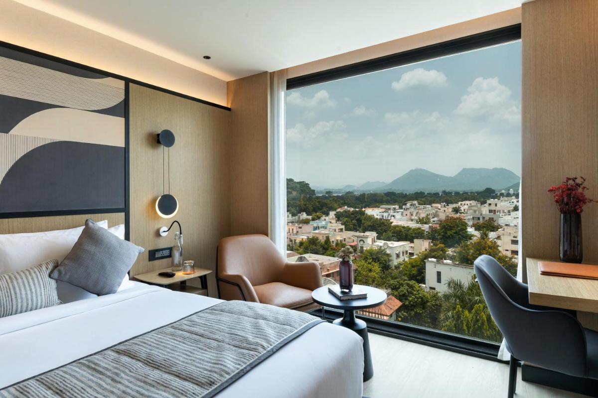 a hotel room with a bed and a large window at Parallel Hotel Udaipur, a member of Radisson Individuals in Udaipur