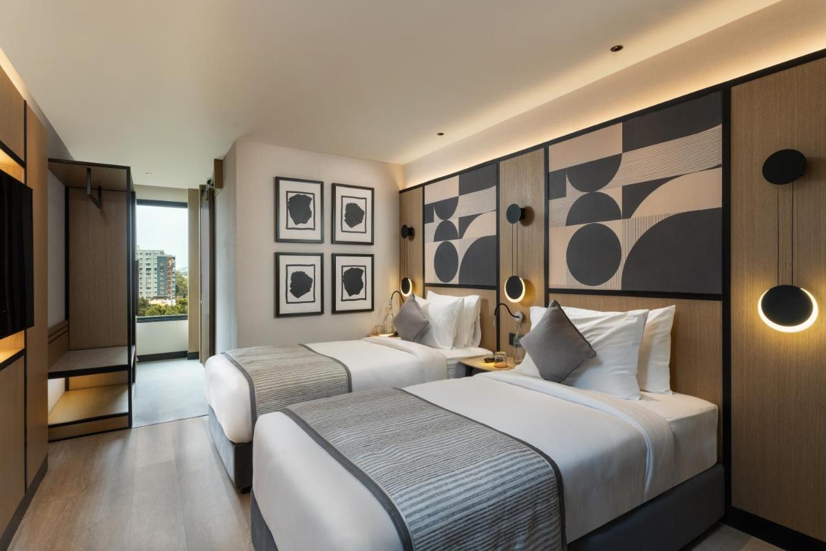 a hotel room with two beds and a television at Parallel Hotel Udaipur, a member of Radisson Individuals in Udaipur