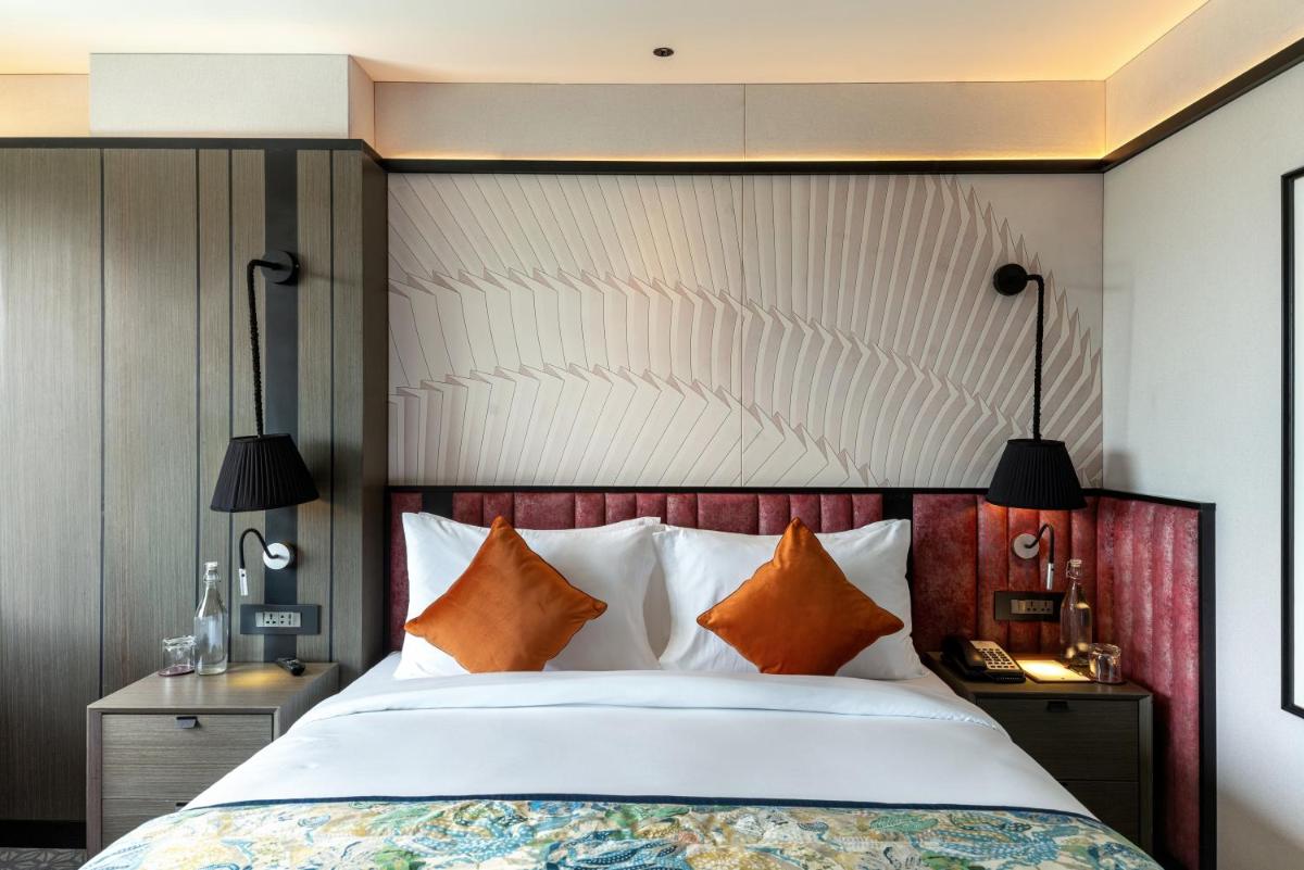 a bedroom with a large bed with orange pillows at Parallel Hotel Udaipur, a member of Radisson Individuals in Udaipur