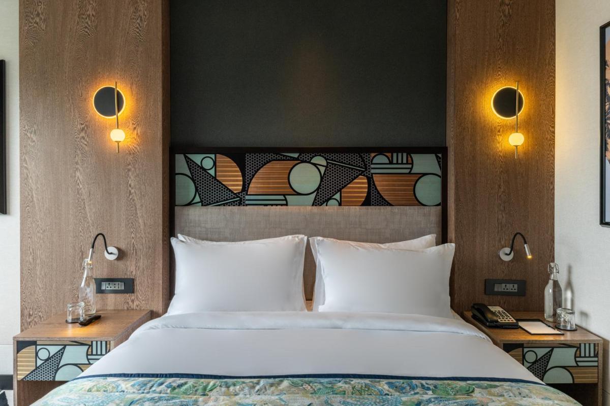 a bedroom with a large bed with white pillows at Parallel Hotel Udaipur, a member of Radisson Individuals in Udaipur