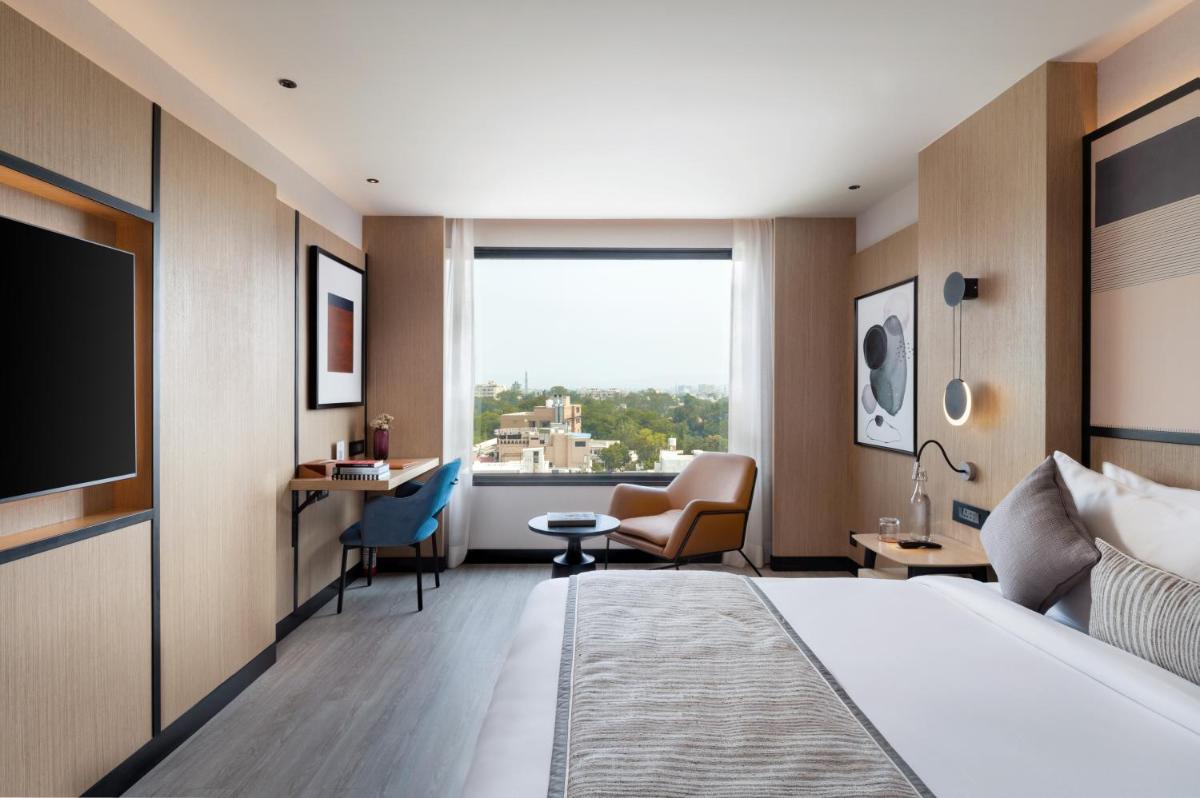 a hotel room with a bed and a large window at Parallel Hotel Udaipur, a member of Radisson Individuals in Udaipur