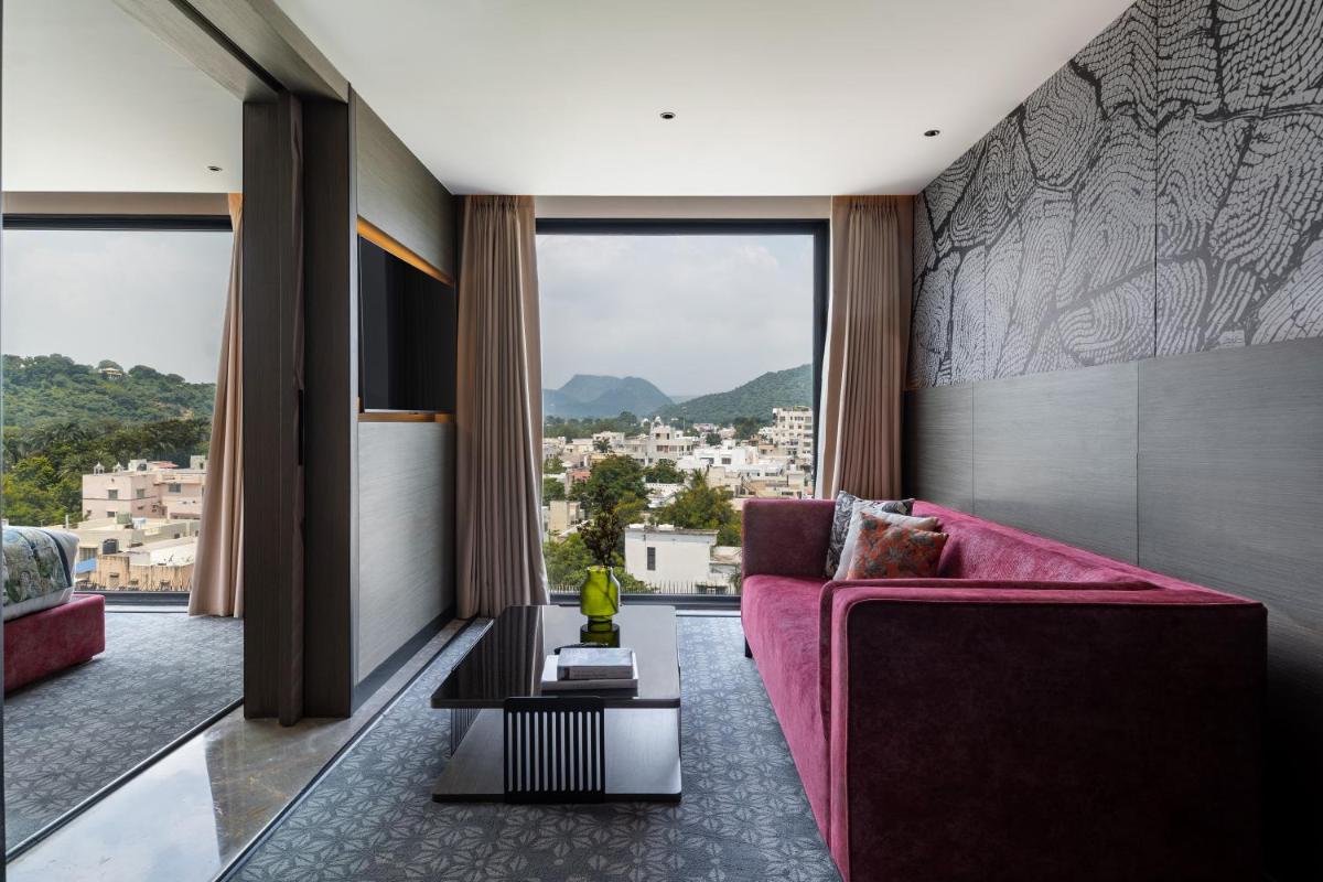 a living room with a pink couch and large windows at Parallel Hotel Udaipur, a member of Radisson Individuals in Udaipur