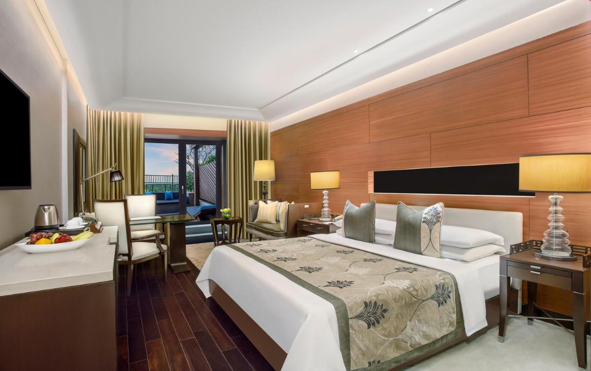 a hotel room with a large bed and a desk at The Leela Ambience Gurugram Hotel & Residences - The Luxury Urban Sanctuary in Gurgaon