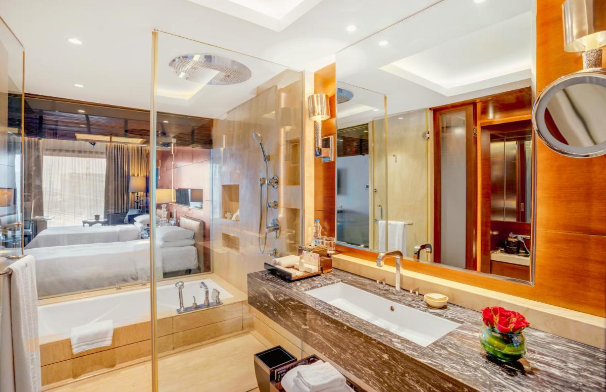 a bathroom with a large sink and a tub at The Leela Ambience Gurugram Hotel & Residences - The Luxury Urban Sanctuary in Gurgaon